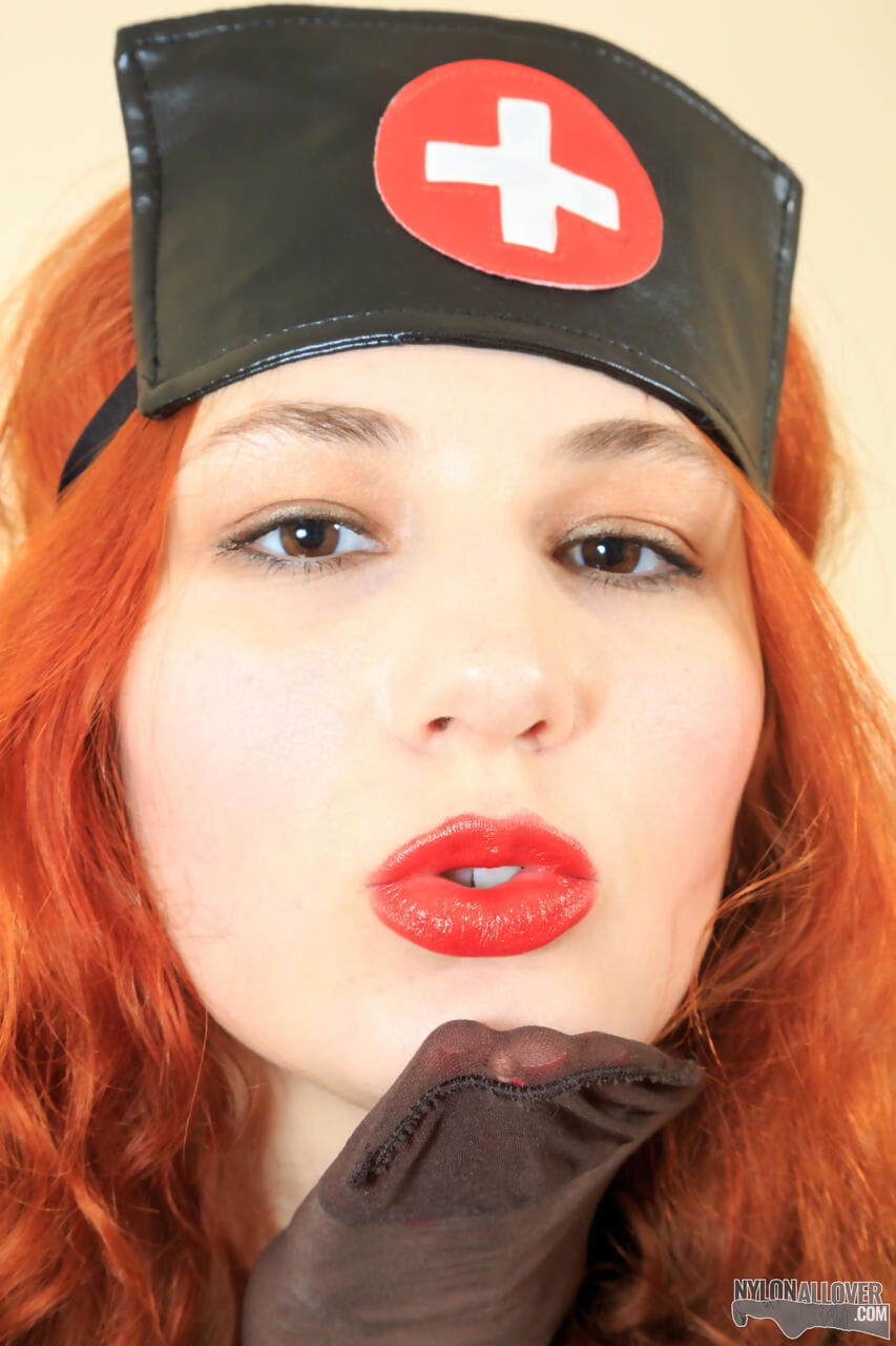 Redhead in latex nurse attire pulls on pantyhose all over her body page 1