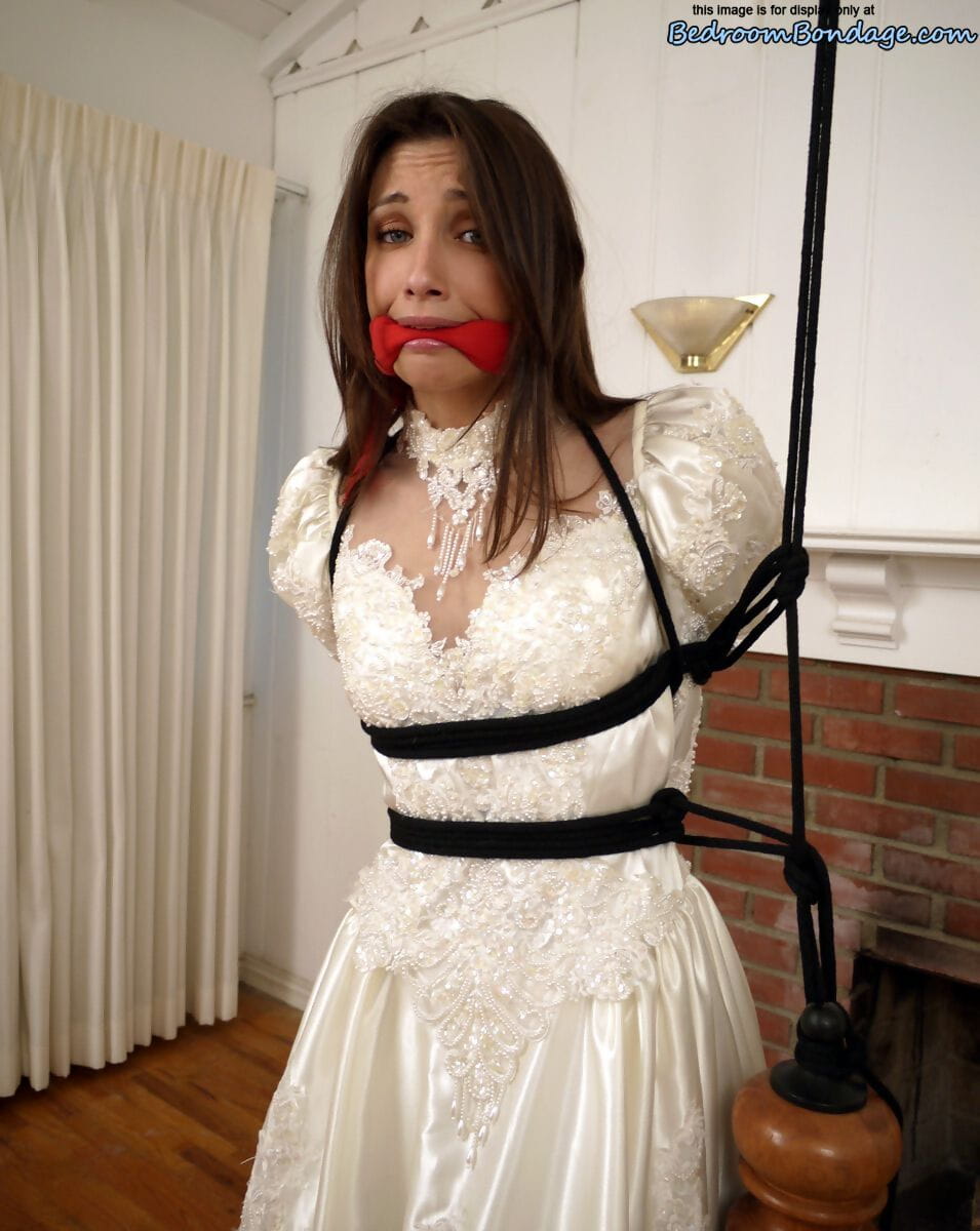 Brunette bride Celeste Star is ballgagged and tied up in her wedding dress page 1