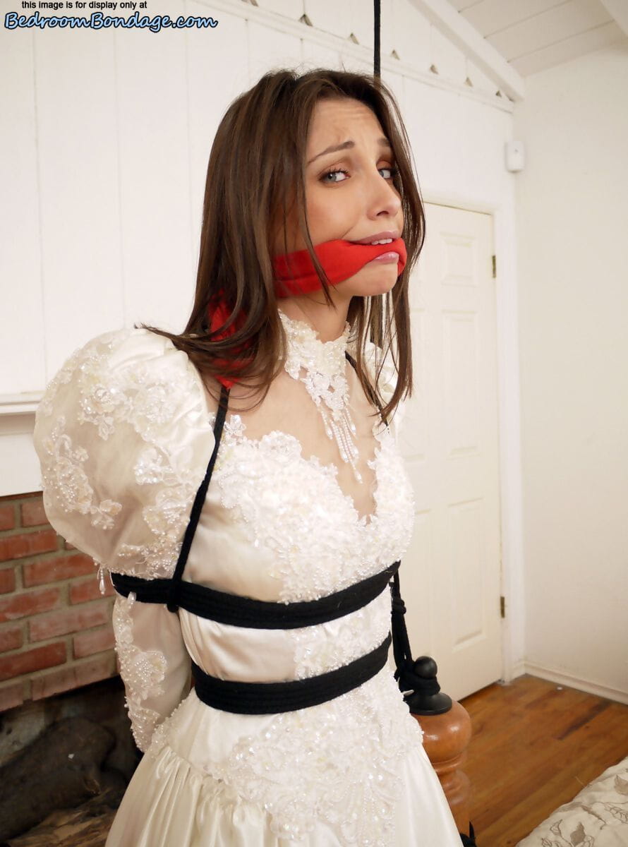 Brunette bride Celeste Star is ballgagged and tied up in her wedding dress page 1