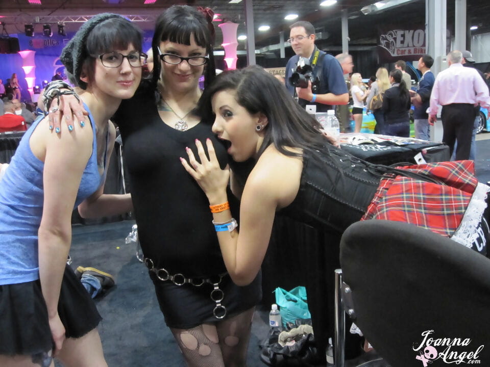 Tattooed alt models kiss and fool around during an XXX trade show page 1