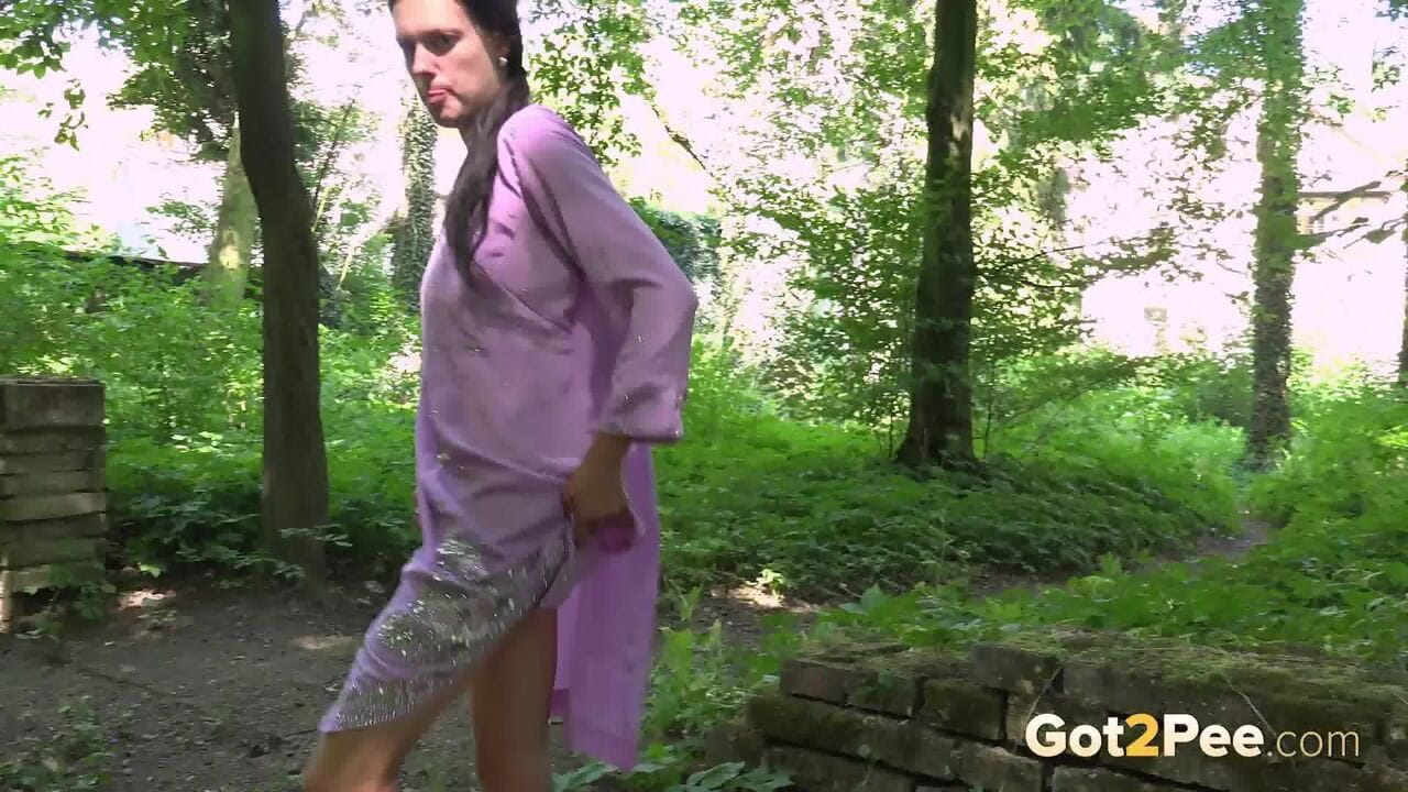 Brunette female takes a badly needed pee in the middle of a forest page 1