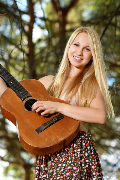 Sweet young blonde with tiny titties gets naked in the woods to play guitar